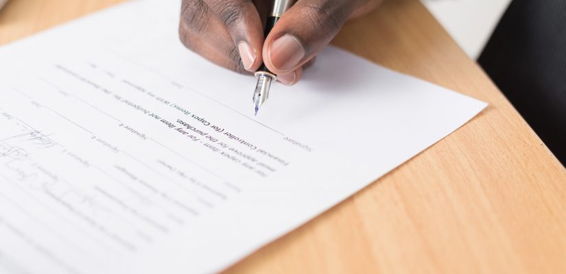 Jeune homme qui signe son contrat d'assurance loyer impayé